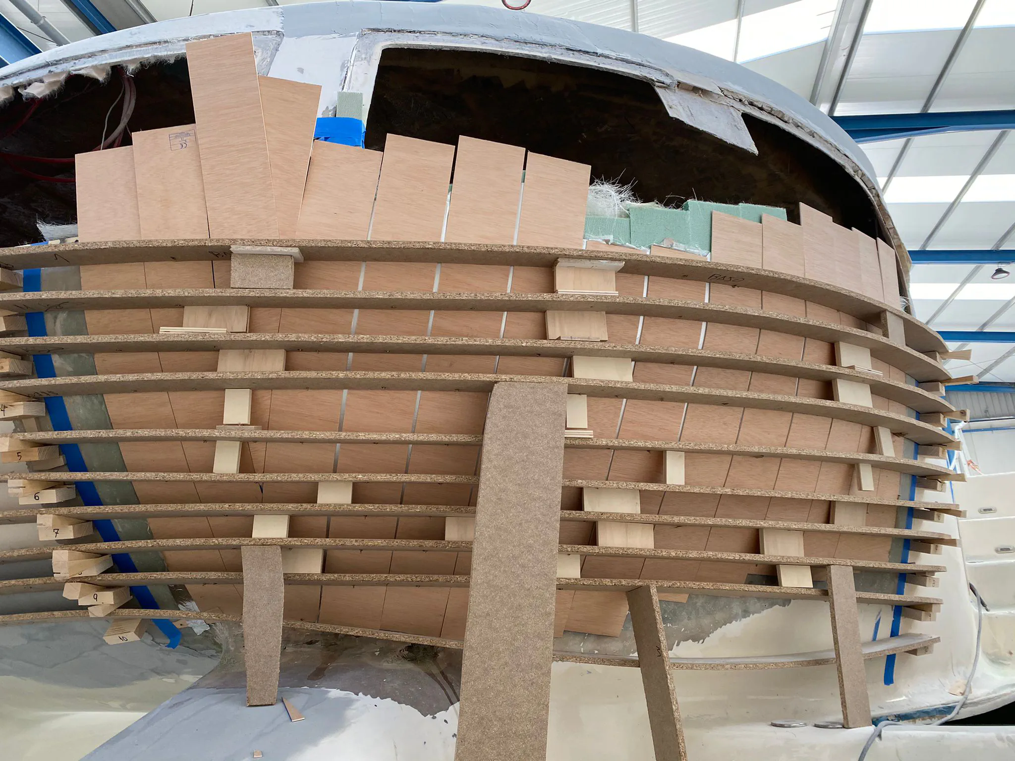 A custom-built wooden mold clamped to the aft cabin to guide the fiberglass rebuild.