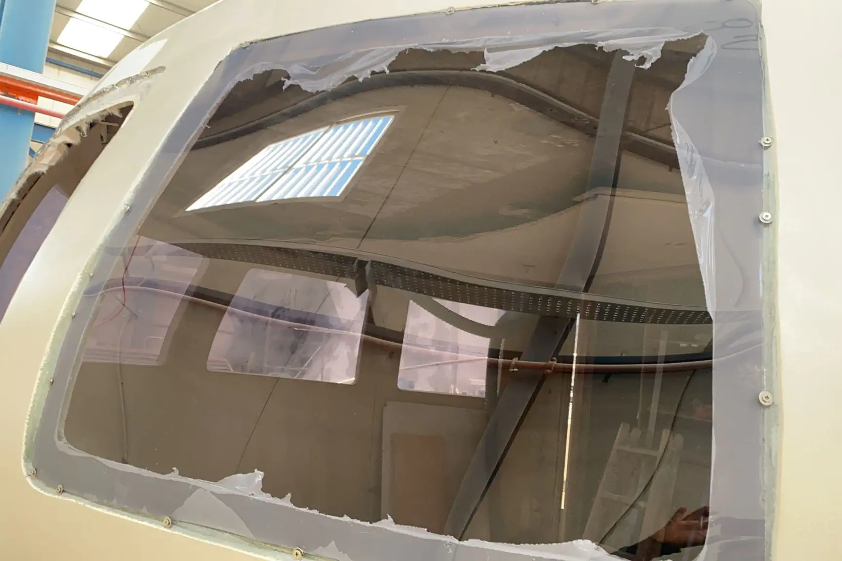 Une feuille de méthacrylate en cours d'essai dans le cadre d'un hublot de la cabine arrière.