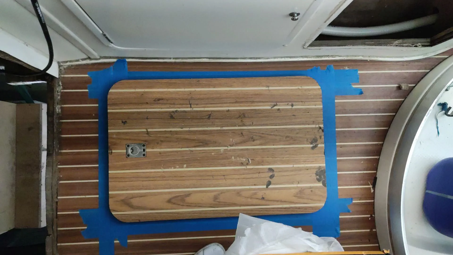 Marking the floor for the new hatch cut using an existing hatch as a template.