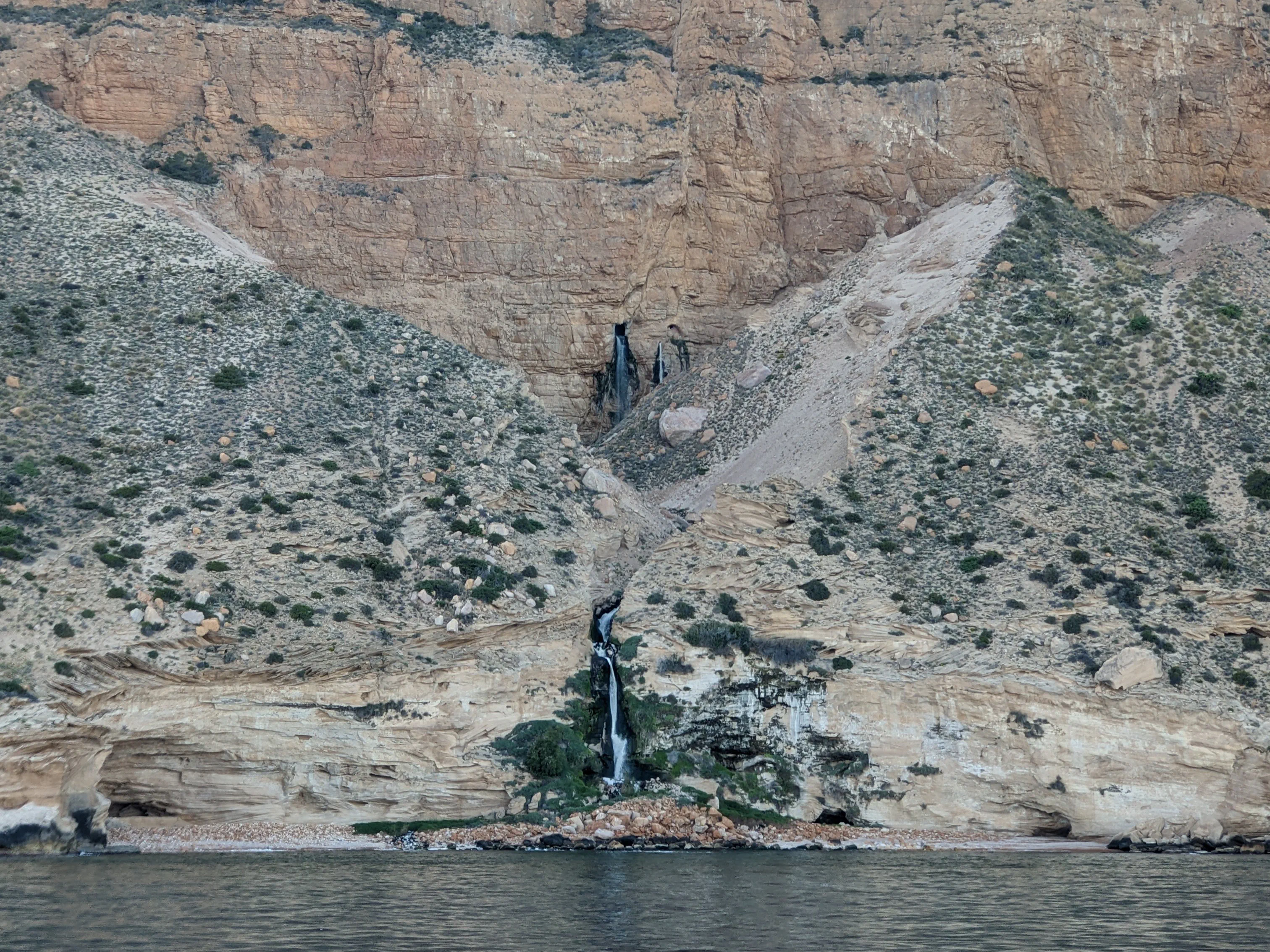 Cliffside Waterfalls A waterfall cascading from the rocky cliffs into the Mediterranean
